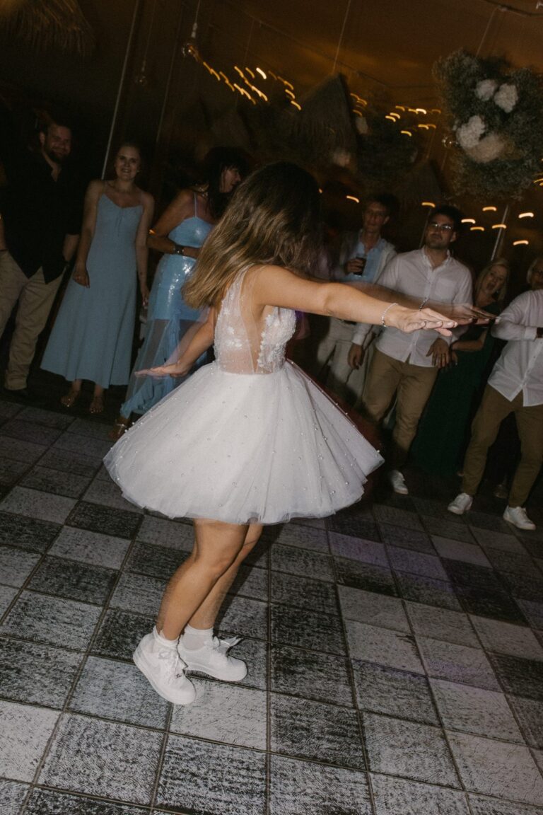 Bride and groom celebrating with champagne, both in custom sneakers